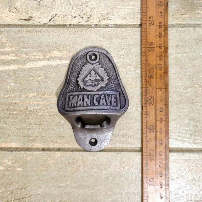 The Man Cave Wall Mounted Bottle Opener is crafted from durable cast iron with an antique iron finish.