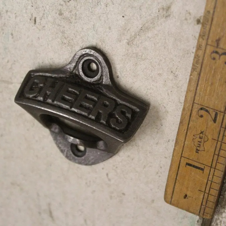 Cheers on a wall mounted antique iron bottle opener