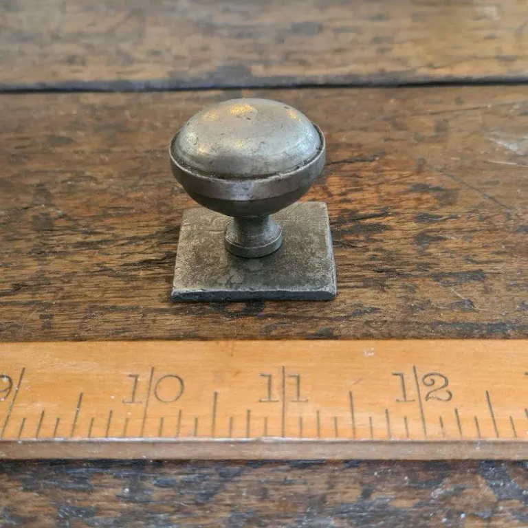 Classic style knob on a square back plate in antique iron